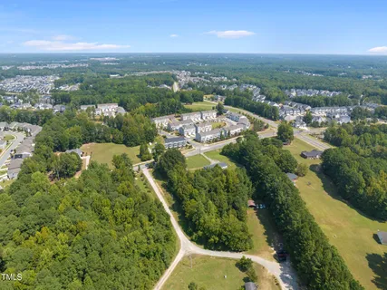 an aerial view of residential houses with outdoor space and trees