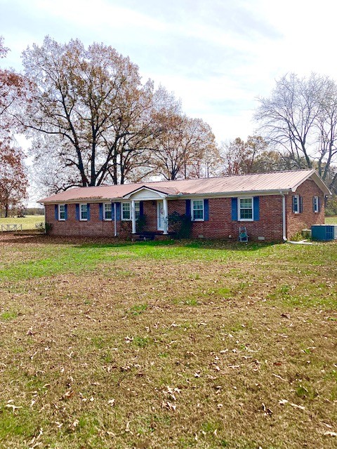 front view of house with a yard and potted plants