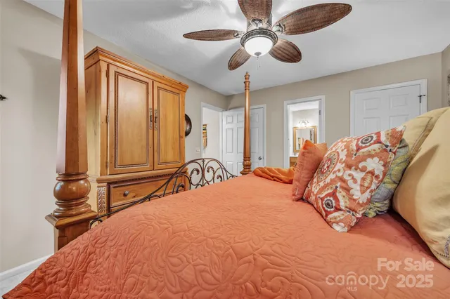 a bedroom with a large bed and a chandelier