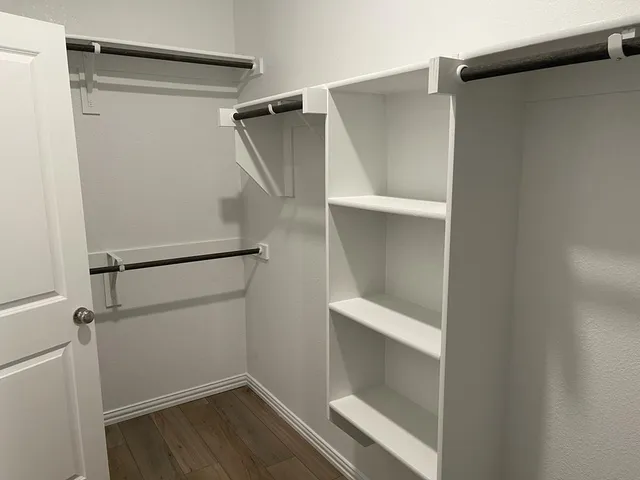 a view of walk in closet with empty racks
