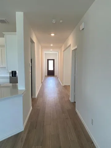 a view of a hallway with wooden floor and staircase