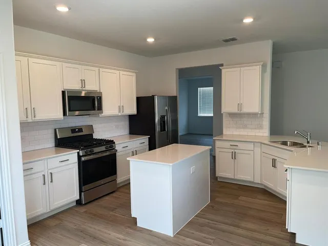 a kitchen with a stove a sink and a refrigerator