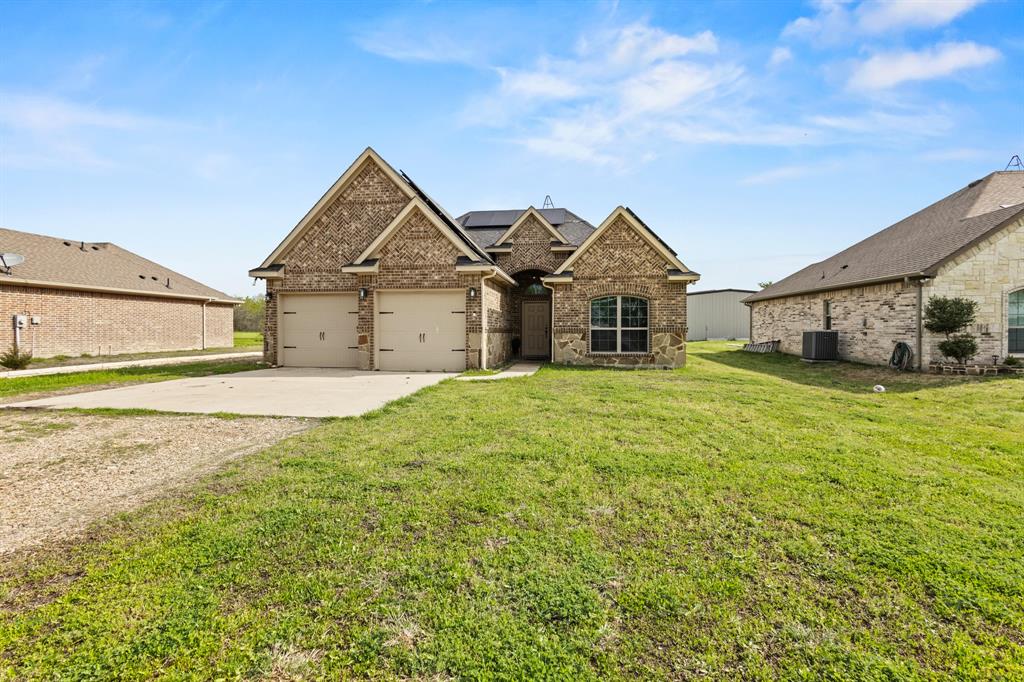 a front view of a house with a garden and yard