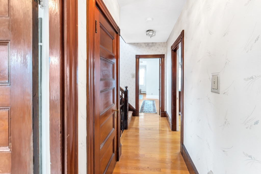 196 Maple Street Boston, MA 02132 - Photo 15 of 33 a view of a hallway with wooden floor and a bathroom