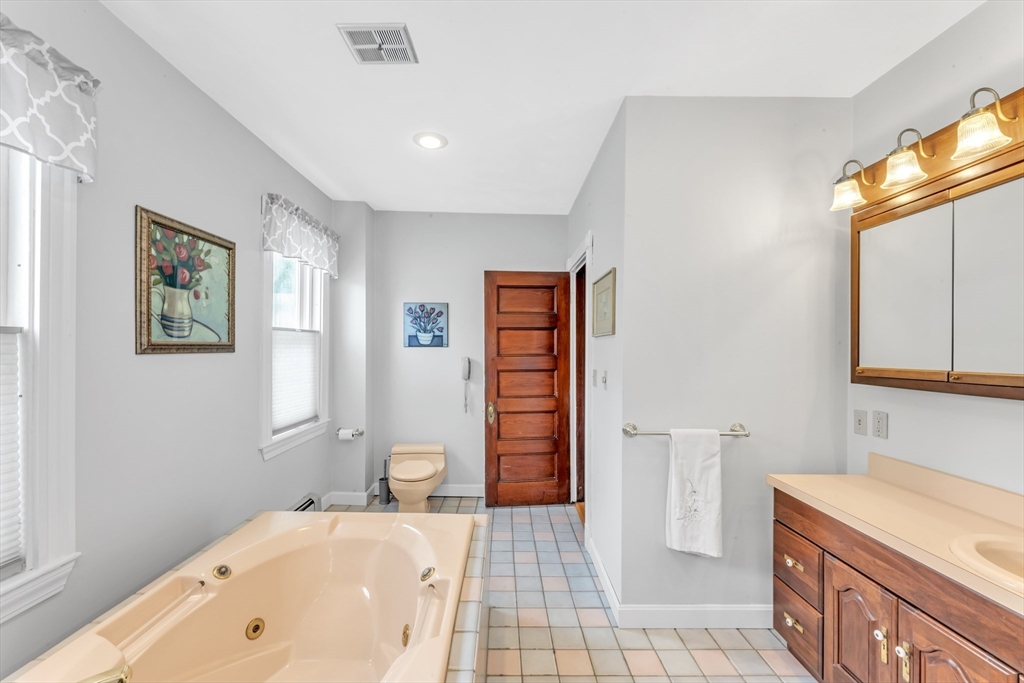 196 Maple Street Boston, MA 02132 - Photo 20 of 33 a bathroom with a tub sink and a mirror