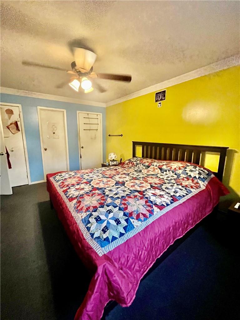 1012 East 172nd Street Bronx, NY 10460 - Photo 12 of 25 Bedroom with dark colored carpet, ceiling fan, a textured ceiling, and ornamental molding