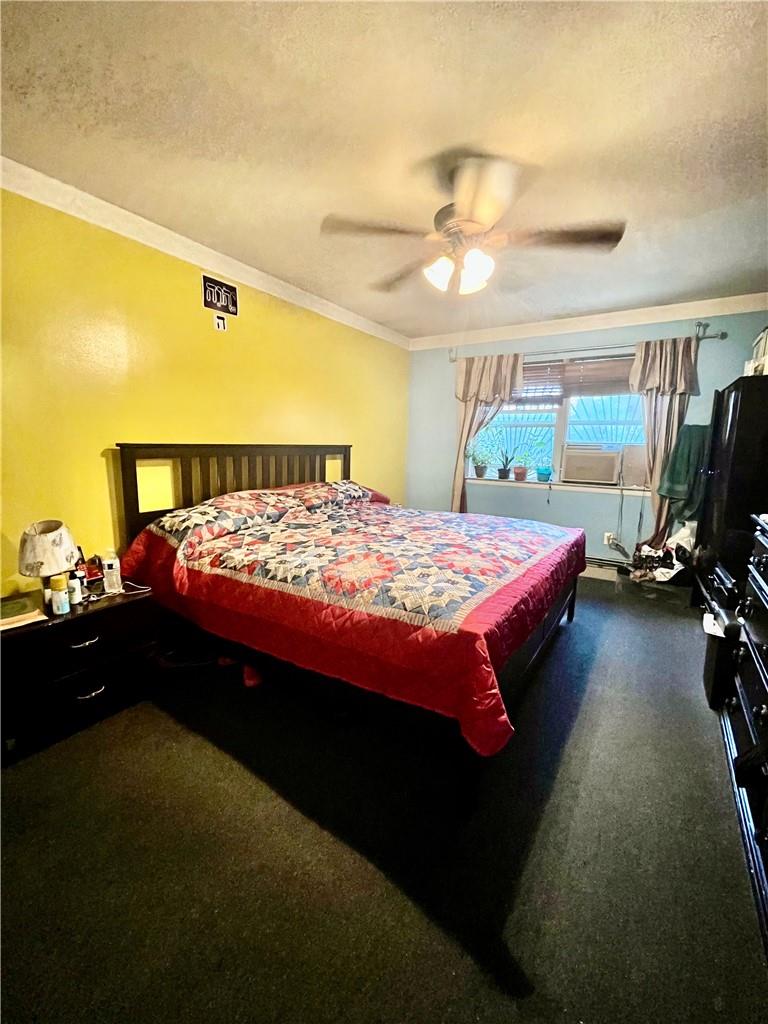 1012 East 172nd Street Bronx, NY 10460 - Photo 13 of 25 Bedroom featuring a textured ceiling, carpet, crown molding, and ceiling fan