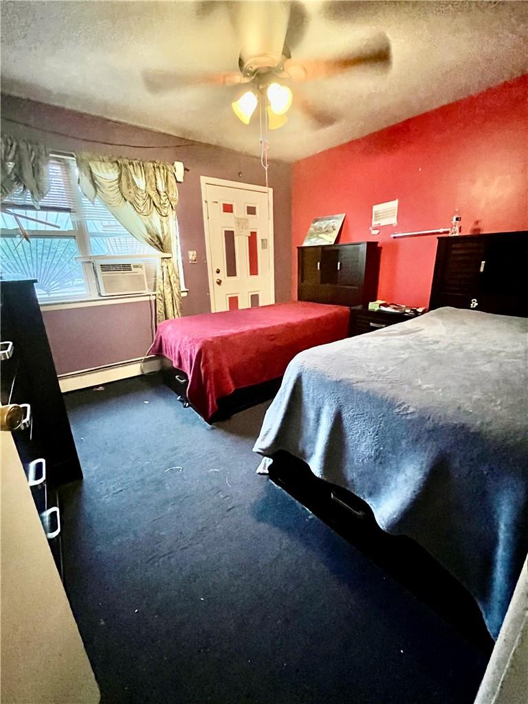 1012 East 172nd Street Bronx, NY 10460 - Photo 16 of 25 Bedroom featuring a textured ceiling, ceiling fan, cooling unit, baseboard heating, and carpet floors