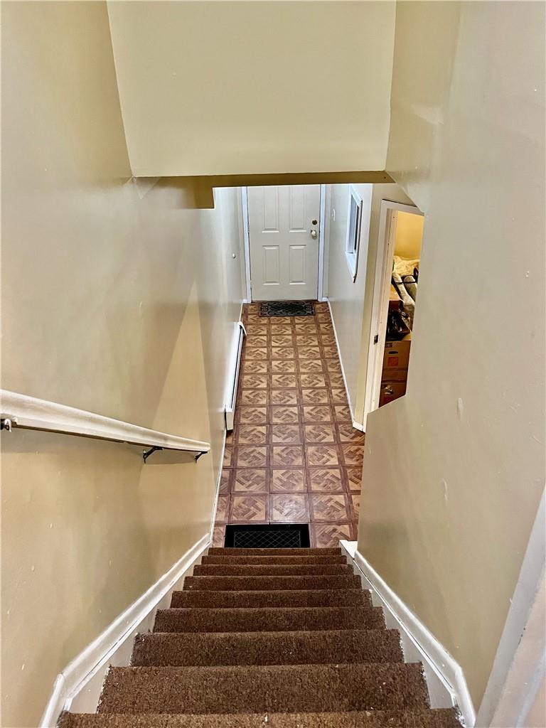 1012 East 172nd Street Bronx, NY 10460 - Photo 19 of 25 Stairway featuring a baseboard radiator and tile patterned flooring