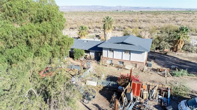 a view of a house with a yard and mountain view in back