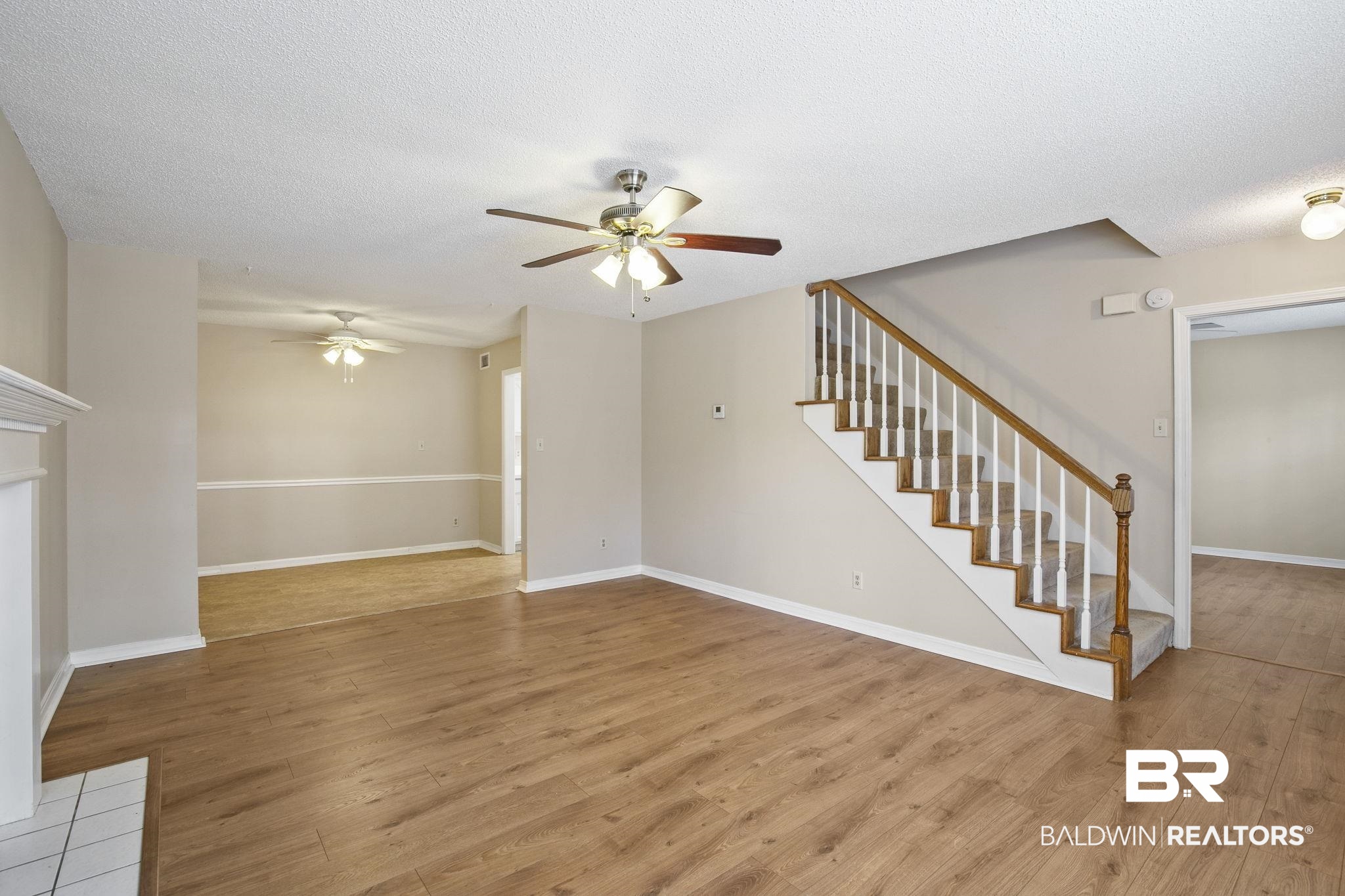 359 Ridgewood Drive Daphne, AL 36526 - Photo 15 of 73 Living room with wood burning fireplace, LVP flooring and ceiling fan.