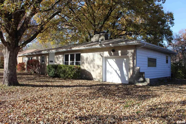 a view of house with backyard and trees