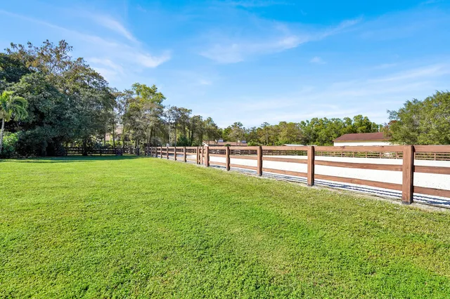 a backyard of a house with lots of green space and fountain