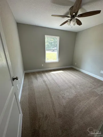 en empty room with windows and fan