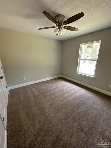 an empty room with a window and a fan