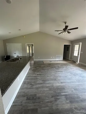 a view of an empty room and kitchen view