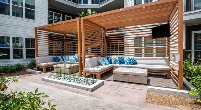 a view of a patio with couches table and chairs and potted plants