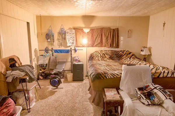 a bedroom with a bed and a computer on the desk