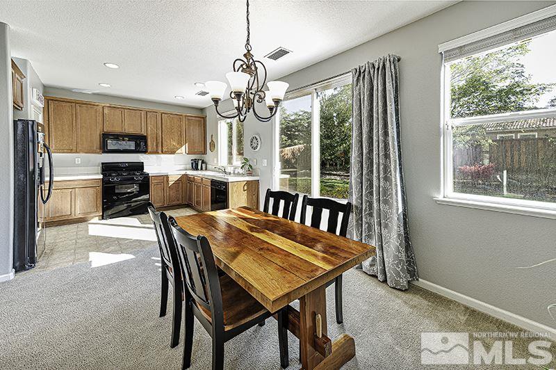 340 Manciano Way Reno, NV 89521 - Photo 4 of 15 a view of a dining room with furniture a chandelier and wooden floor