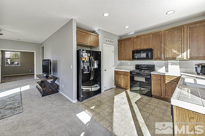 340 Manciano Way Reno, NV 89521 - Photo 6 of 15 a kitchen with stainless steel appliances granite countertop a stove refrigerator and a sink