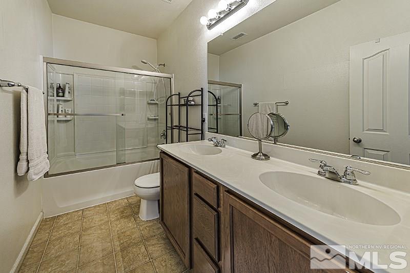 340 Manciano Way Reno, NV 89521 - Photo 9 of 15 a bathroom with a double vanity sink toilet mirror and shower