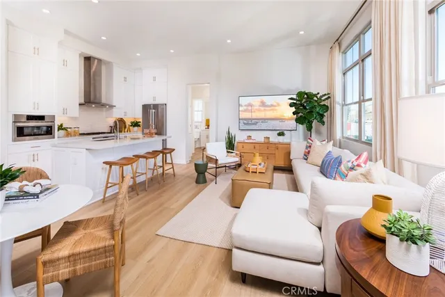 a living room with furniture kitchen and a large window
