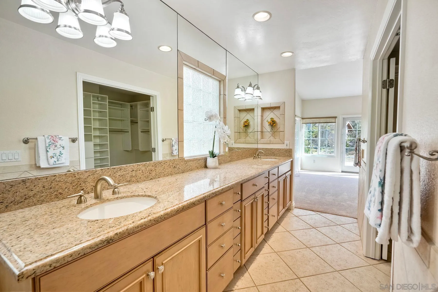 13145 Silver Saddle Lane Poway, CA 92064 - Photo 20 of 53 a bathroom with a granite countertop sink a large mirror and a shower