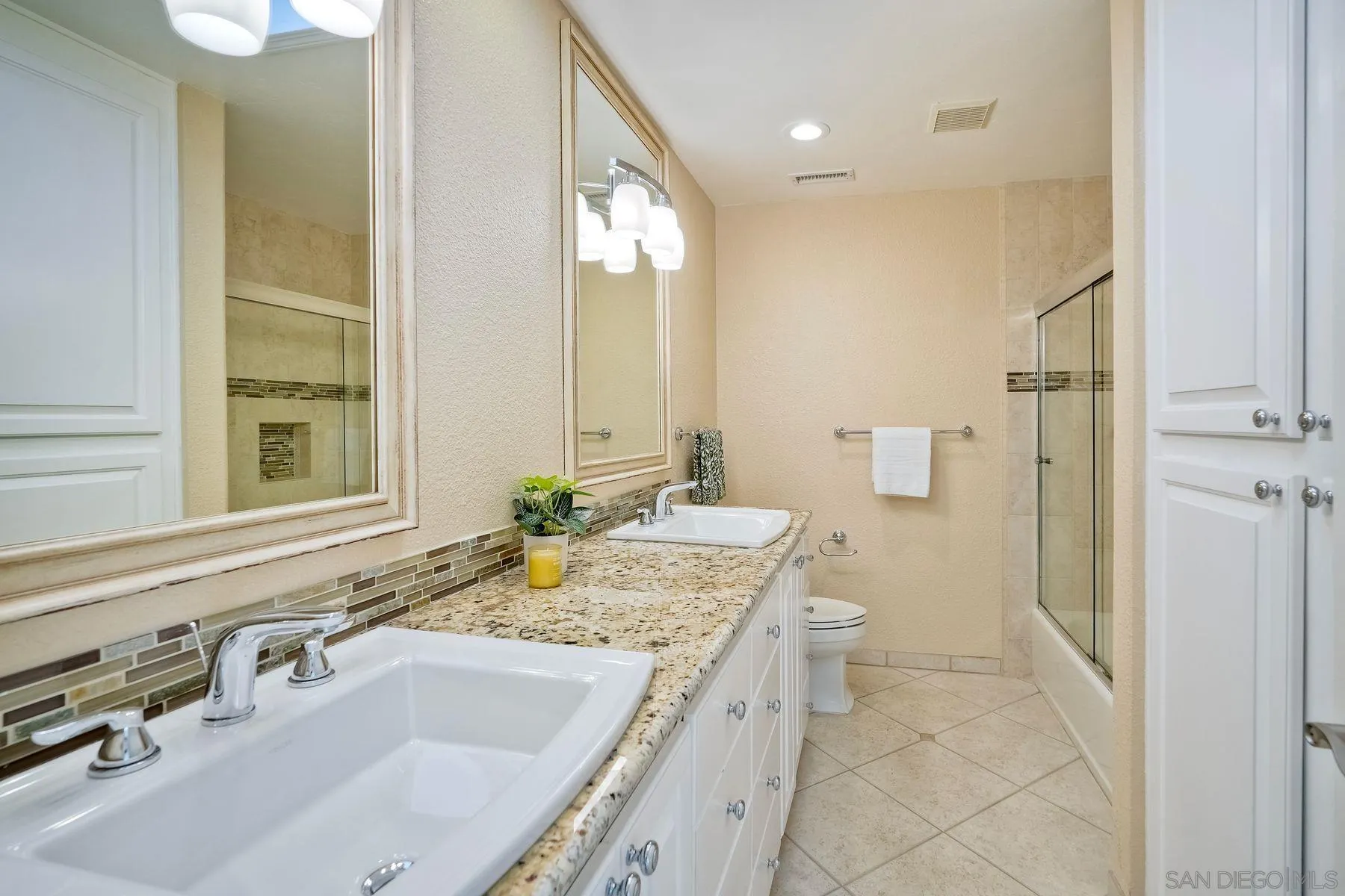 13145 Silver Saddle Lane Poway, CA 92064 - Photo 27 of 53 a bathroom with a granite countertop sink and a large mirror
