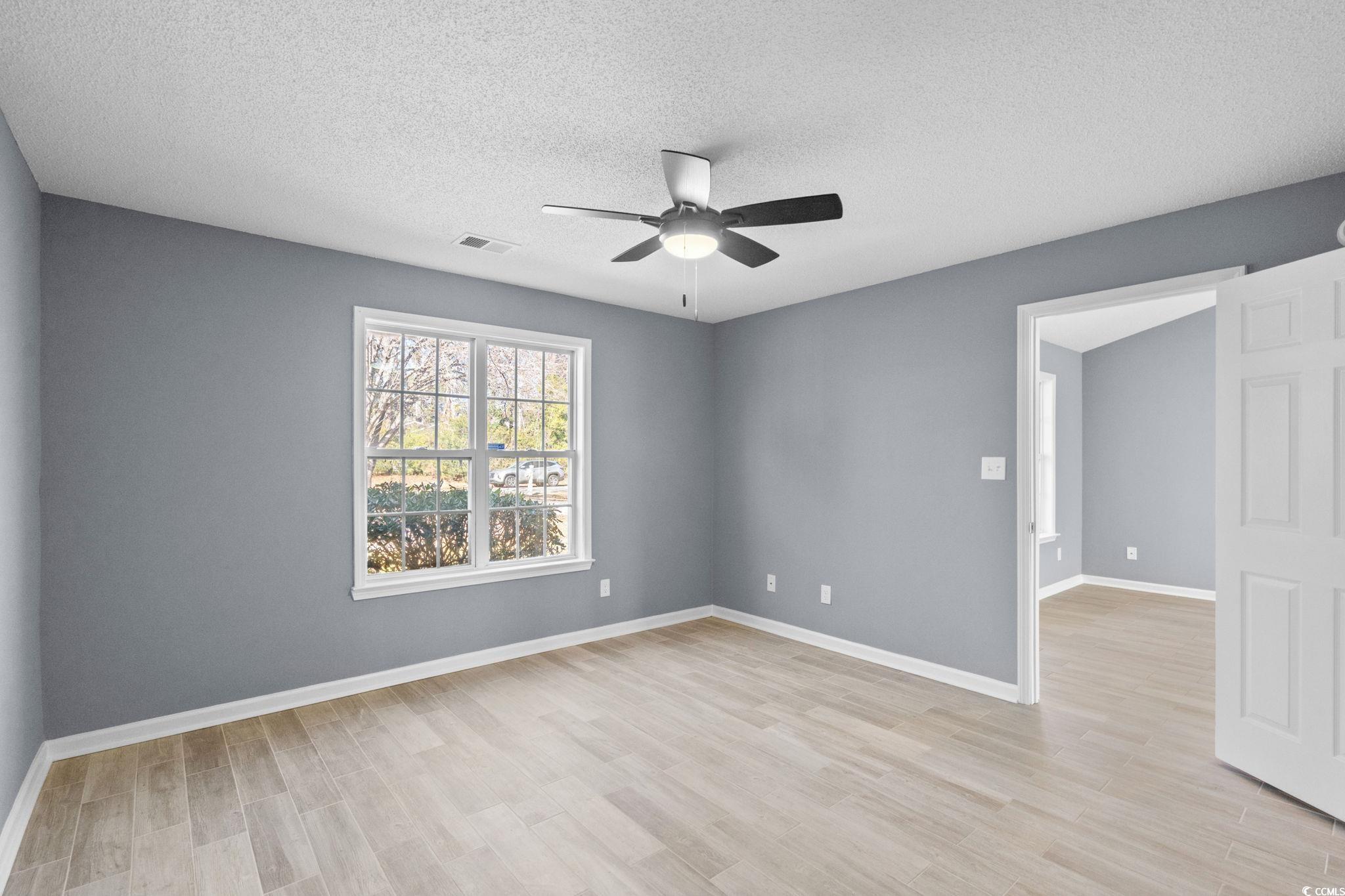 3343 New Road Conway, SC 29527 - Photo 16 of 36 Empty room featuring light wood-type flooring, a textured ceiling, and ceiling fan