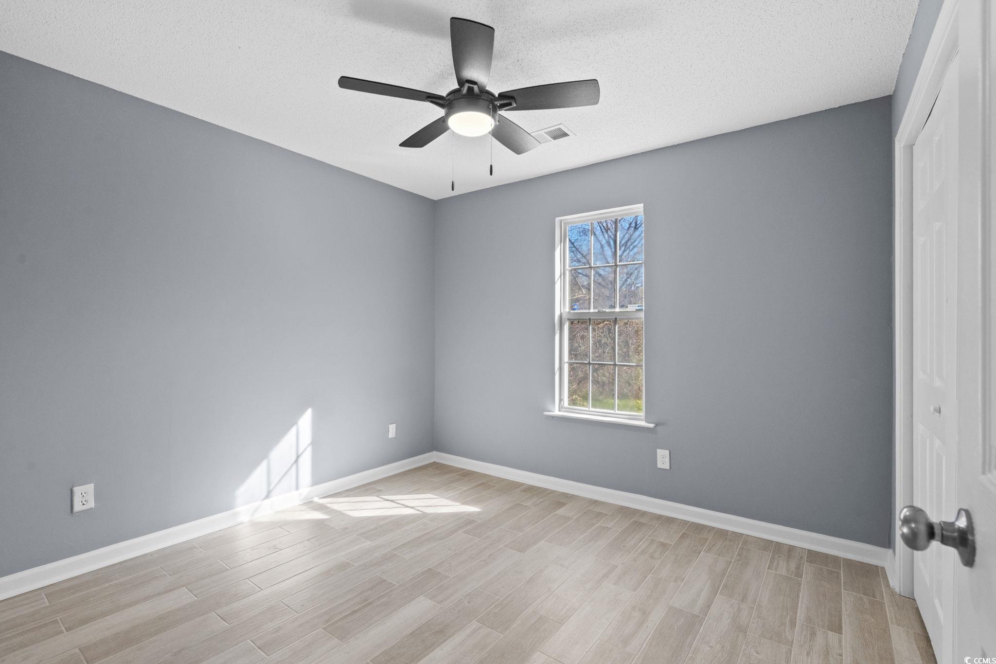 3343 New Road Conway, SC 29527 - Photo 21 of 36 Empty room featuring light wood-type flooring, a ceiling fan, and a textured ceiling