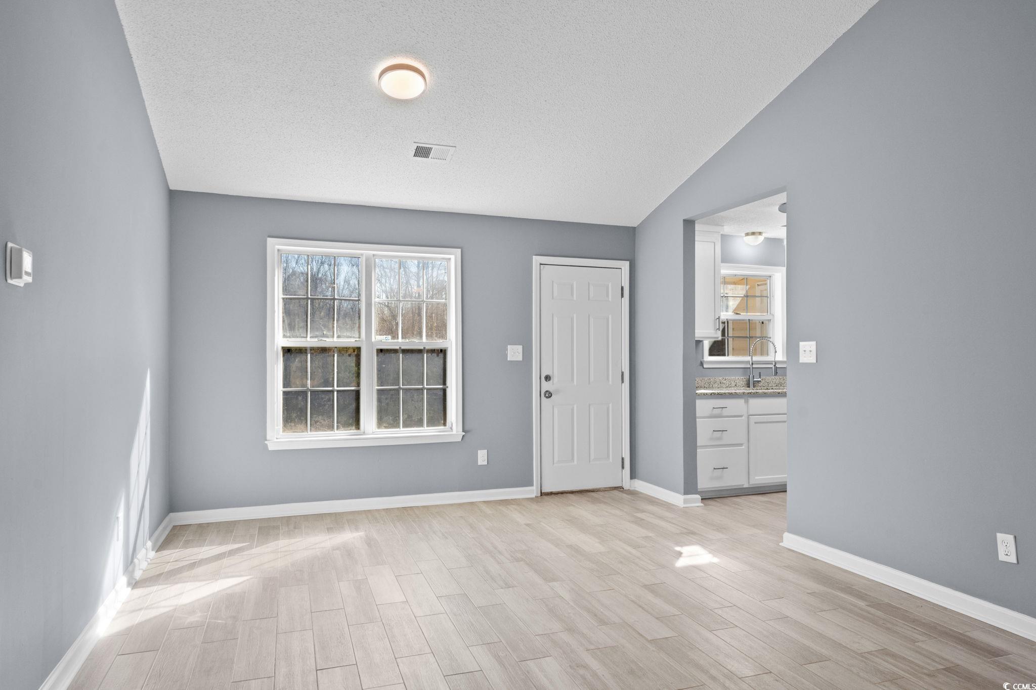 3343 New Road Conway, SC 29527 - Photo 9 of 36 Foyer featuring healthy amount of natural light, a textured ceiling, wood finish floors, and lofted ceiling