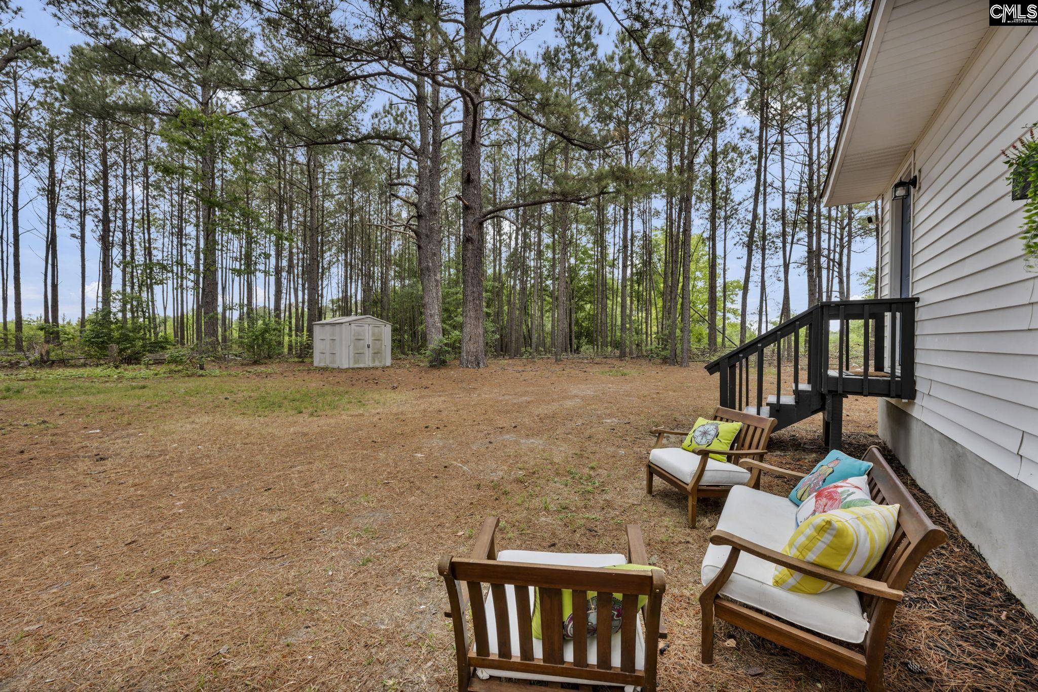 8107 Black River Road Rembert, SC 29128 - Photo 31 of 38 a backyard of a house with table and chairs