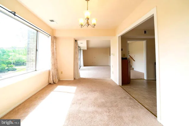 a view of a big room with windows and chandelier