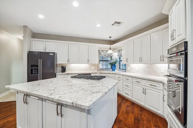 a kitchen with granite countertop a sink stove and refrigerator