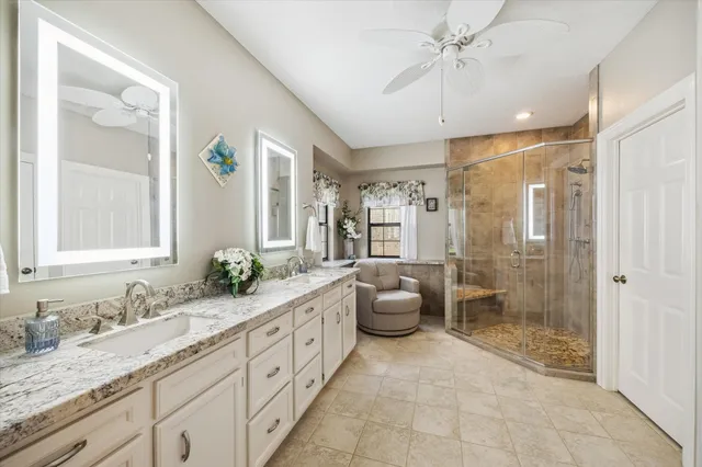 a bathroom with a granite countertop sink mirror and shower