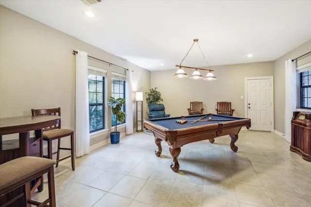 a room with pool table and windows