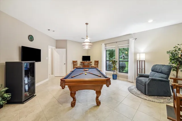 a living room with furniture a flat screen tv and a chandelier