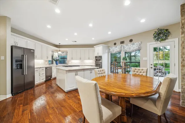 a dining room with furniture a large window and stainless steel appliances