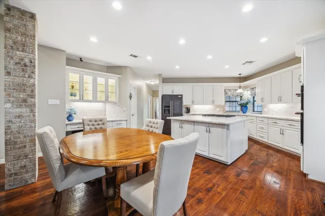 a kitchen with stainless steel appliances wooden floor dining table and chairs