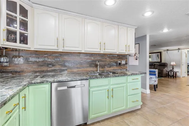 a kitchen with stainless steel appliances granite countertop a sink a stove and cabinets