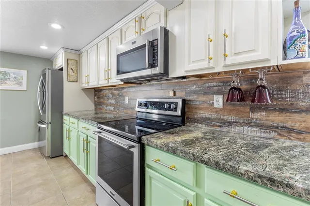 a kitchen with stainless steel appliances granite countertop a stove a microwave and a sink