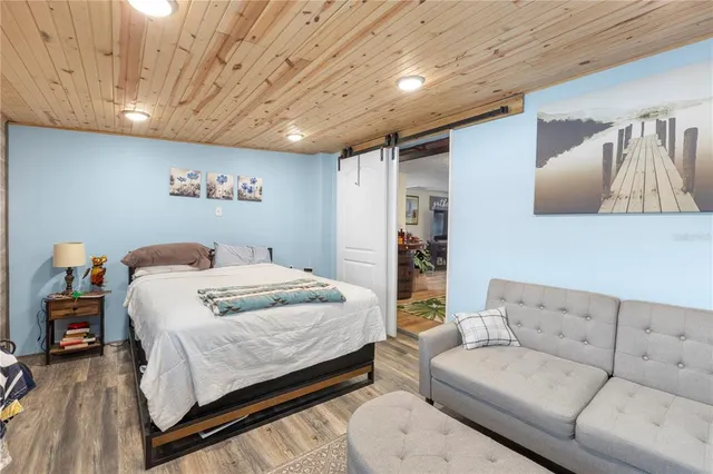 a bedroom with a large bed couch and a large window