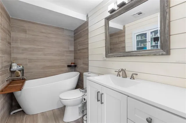 a bathroom with a toilet a sink and mirror