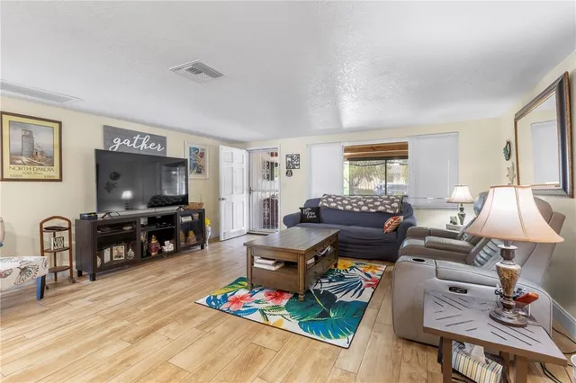 a living room with furniture and a flat screen tv with wooden floor