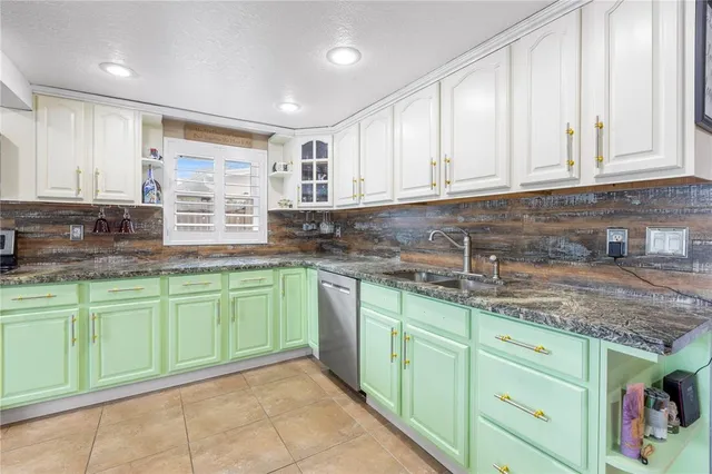 a kitchen with granite countertop cabinets sink and washing machine
