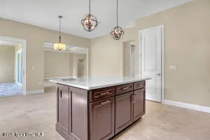 a kitchen with stainless steel appliances granite countertop a stove and a chandelier
