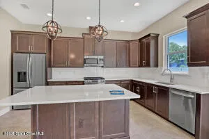 a kitchen with stainless steel appliances a sink stove and refrigerator