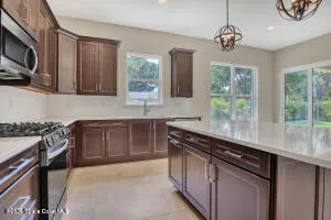 a kitchen with stainless steel appliances granite countertop a stove a sink and a microwave