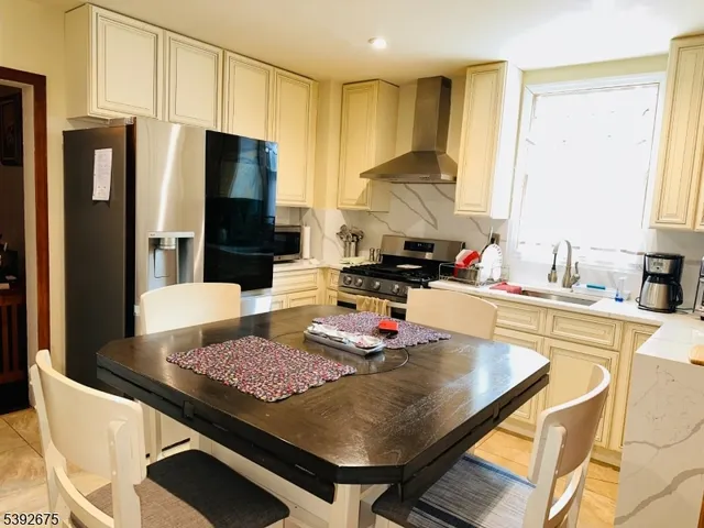 a kitchen with a stove a refrigerator and a dining table