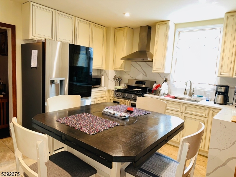 569 Cornell Street Perth Amboy, NJ 08861 - Photo 2 of 11 a kitchen with a stove a refrigerator and a dining table